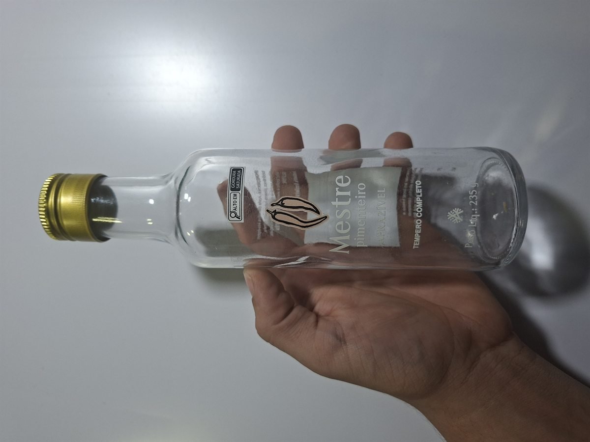 Rótulo em adesivo transparente aplicado em embalagem de vidro